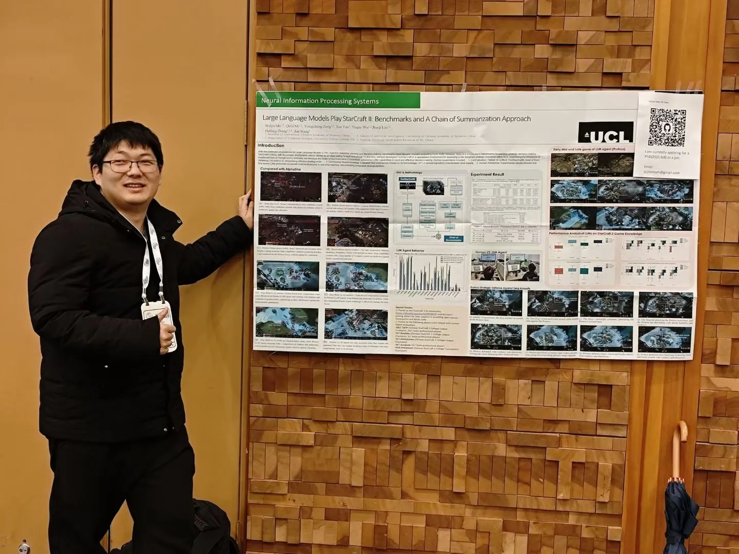 Standing next to the NeurIPS 2024 poster for “Large Language Models Play StarCraft II”
